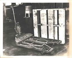 Hydraulic hand pallet truck and double-faced wooden pallet patented by George Raymond, Sr., and William House on Nov. 7, 1939.